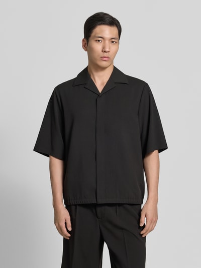 Männermodel trägt Relaxed Fit Hemdjacke mit Reverskragen von Lindbergh, Schwarz, Material-Mix mit Viskose-Anteil, Ganzkörperansicht von vorne. Rückenlänge bei Größe M: 69 cm, Schulterbreite bei Größe M: 48 cm, Ärmellänge bei Größe M: 34 cm.