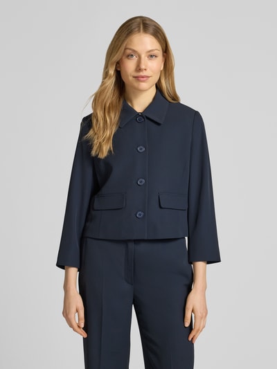 Frauenmodel trägt Regular Fit Blazer mit Umlegekragen von Betty Barclay, Elastischer-Material-Mix, Pattentaschen, durchgängige Knopfleiste, taillierte Passform, Rückenlänge 49 cm, Brustweite 47 cm, Ärmellänge 52 cm, dunkelblau, glatte Textur, Ganzkörperansicht von vorne.