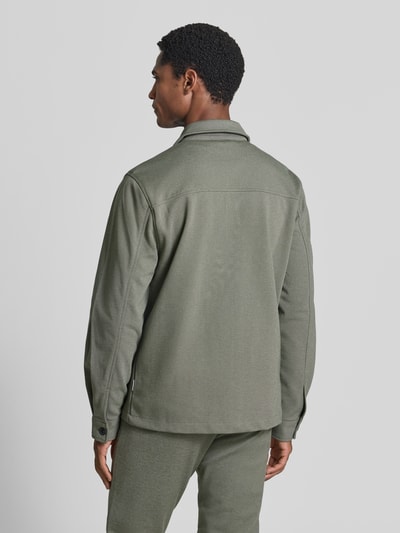 Männermodel trägt Slim Fit Hemdjacke mit Viskose-Anteil von Lindbergh in Olivgrün, elastischer Stoff, Rückenansicht, Ganzkörperansicht Rückansicht.