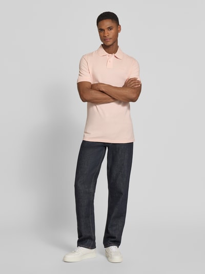 Mannenmodel draagt Regular Fit Poloshirt uit zuivere katoen model 'PRIME' van BOSS Orange, effen lichtroze, piqué structuur, polokraag, korte knoopsluiting, korte mouwen, labelapplicatie, v-hals; full body vooraanzicht.