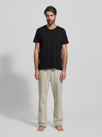 Männermodel trägt schwarzes, unifarbenes T-Shirt mit V-Ausschnitt aus Baumwolle, gerader Schnitt, BOSS ComfortS, Ganzkörperansicht von vorne.