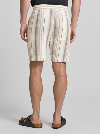 Männermodel trägt Regular Fit Shorts aus reiner Baumwolle Modell 'REGCAL' von SELECTED HOMME, gestreift, Gesäßtasche, Ganzkörperansicht Rückansicht.