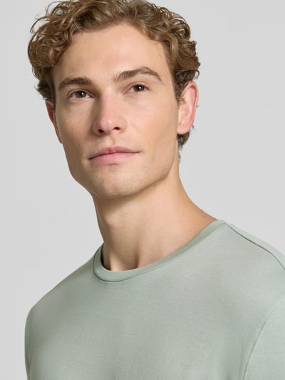 Männermodel trägt Longsleeve mit Rundhalsausschnitt von Christian Berg Men in Hellgrün aus reiner Baumwolle, Nahaufnahme Oberkörper. Slim Fit, Rückenlänge bei Größe M 70 cm.