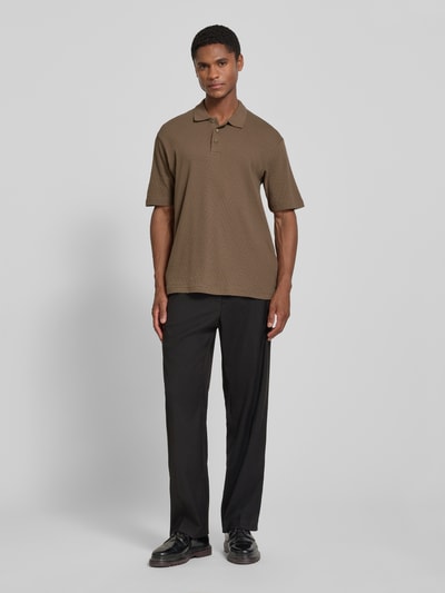 Männermodel trägt Regular Fit Poloshirt mit Knopfleiste von JACK & JONES Premium, Strukturmuster, Label-Detail, Ganzkörperansicht von vorne.