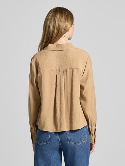 Männermodel trägt Relaxed Fit Bluse aus Modal-Mix Modell 'Flowy' von OPUS, beżowy kolor, kołnierzyk koszulowy, dżinsy, krótka długość, widoczne tekstury materiału, krój relaxed fit, długość z tyłu w rozmiarze 36: 55 cm, długość rękawa: 60 cm, ujęcie całej sylwetki z tyłu.