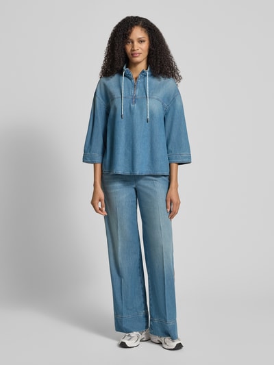 Vrouwenmodel draagt Jeansshirt met Stehkragen und Reißverschluss van Marc Cain, mix van katoen en lyocell, relaxed fit, opstaande kraag, tunnelkoord, ritssluiting, 3/4-mouw, ruglengte maat 36: 62 cm, mouwlengte maat 36: 43 cm, blauwe tinten, soepele structuur, ganzkörperansicht van voren.
