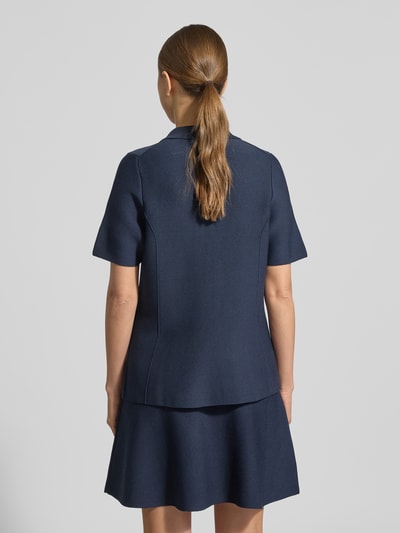 Frauenmodel trägt Strickshirt aus Viskose-Mix mit Knopfleiste von Christian Berg Woman Selection in Dunkelblau, kurzärmelig, Ganzkörperansicht Rückansicht. Regular Fit, Umlegekragen, glatte Textur, Rückenlänge 51 cm bei Größe 36, Ärmellänge 23 cm.
