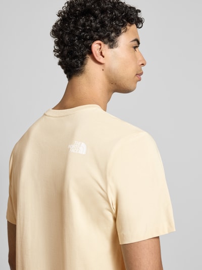 Männermodel trägt Regular Fit T-Shirt mit Logo-Print von The North Face in Beige, Baumwoll-Mix, Rundhalsausschnitt, Rückenlänge 70 cm, Ganzkörperansicht Rückansicht.