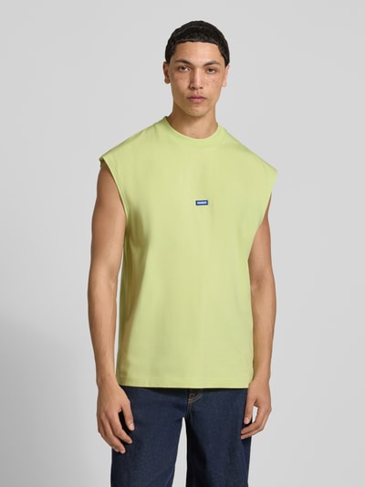 Männermodel trägt Relaxed Fit Tank Top aus reiner Baumwolle Modell 'NAVERTZ' von HUGO Blue in Unifarbe mit Label Patch, Ganzkörperansicht von vorne.