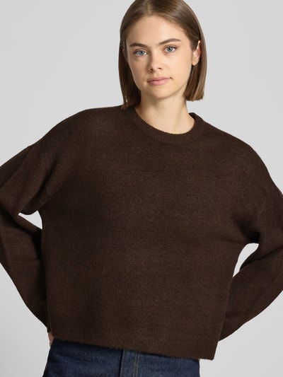 Frauenmodel trägt Relaxed Fit Pullover mit Rundhalsausschnitt Modell 'SIMONI' von ONLY in Dunkelbraun, Damen Pullover von ONLY, Nahaufnahme Oberkörper.