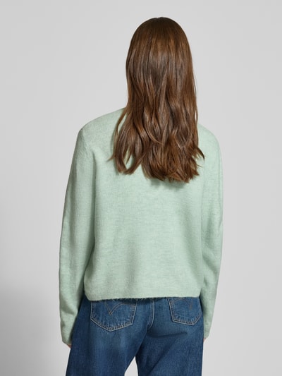 Frauenmodel trägt Regular Fit Strickjacke mit einreihiger Knopfleiste Modell 'SIMONI' von ONLY, Optik: Unifarben, langarm, Rundhals, gerippt, Materialverarbeitung: Strick, Ganzkörperansicht Rückansicht.