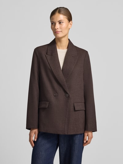 Vrouwenmodel draagt Loose Fit Longline Blazer met schoudervullingen van VERO MODA, effen bruin, reverskraag, sierknopen, webstof, lange mouw, klepzakken, 2-knoopsluiting, voorkant bovenlichaam dicht bij Ganzkörperansicht von vorne.