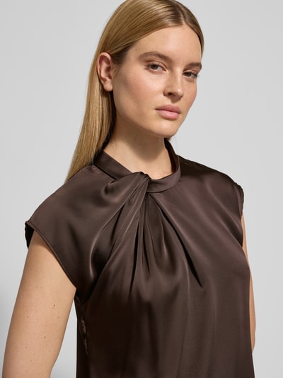 Frauenmodel trägt Regular Fit Bluse mit Raffungen Modell 'Fleur' von Neo Noir aus braunem Satin, Stehkragen, kurzärmelig, Nahaufnahme Oberkörper. Rückenlänge bei Größe 36: 59 cm.