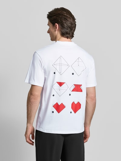 Männermodel trägt Regular Fit T-Shirt aus reiner Baumwolle Modell 'DALENTIN' von HUGO, weiß, Motiv-Print Origami, Ganzkörperansicht Rückansicht.