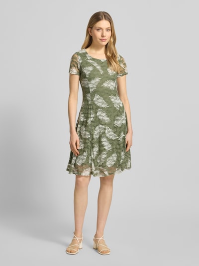 Frauenmodel trägt Knielanges Kleid mit Rundhalsausschnitt von Apricot mit grün-weißem Muster, Material-Mix mit Stretch-Anteil, A-Linie, Unterkleid, Ganzkörperansicht von vorne. Rückenlänge ca. 93 cm, Brustweite ca. 41 cm, Ärmellänge ca. 17 cm, blickdicht.