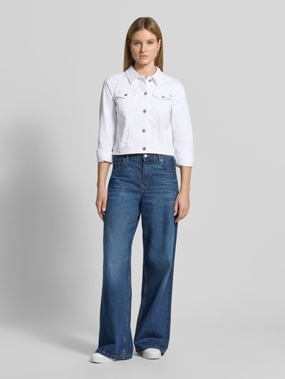 Modelka kobieca nosi Slim Fit Jeansjacke aus Baumwoll-Mix od Tommy Hilfiger, biała kurtka jeansowa, długi rękaw, kołnierz klasyczny, kieszenie na piersi i boczne, materiał typu denim, krój slim fit, bawełniany twill, detal z logo, widok całej sylwetki z przodu.