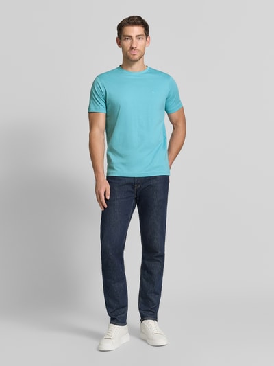 Męski model nosi T-Shirt mit Rundhalsausschnitt und Logo-Stitching von Lerros, jasnoniebieski, bawełna, krój regular fit, okrągły dekolt, wyhaftowane logo, Długość tyłu w rozmiarze M: 77 cm, Ganzkörperansicht von vorne.