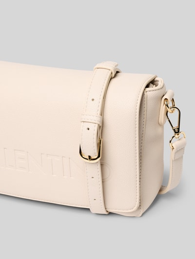 Produktfoto, Handtasche mit Logo-Prägung Modell 'Foxy' von VALENTINO BAGS in Creme mit Strukturmuster, goldener Schnalle, Detailaufnahme. Hauptfach mit Reißverschluss, abnehmbarer Schulterriemen, Magnetverschluss, Innenfach mit Zipper, Maße: 27x18x8 cm, Riemenlänge 130 cm.