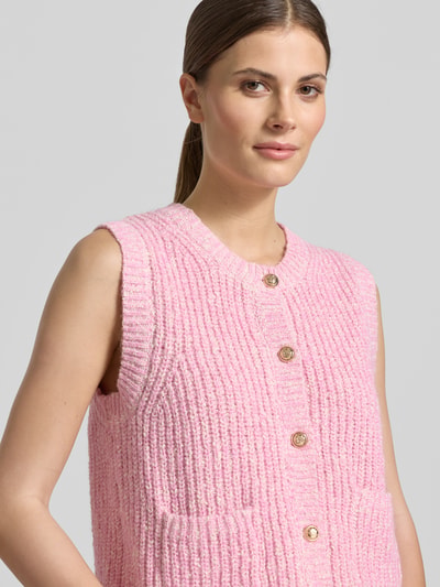 Frauenmodel trägt Strickweste Melange Effekt mit Schmuckknopf von Christian Berg Woman in Rosa mit Rundhalsausschnitt, Nahaufnahme Oberkörper.