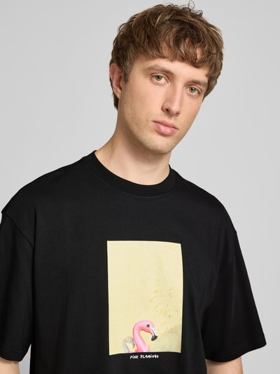 Männermodel trägt Oversized T-Shirt aus reiner Baumwolle Modell 'COOPER' von Only & Sons, Optik: Unifarben, Motiv-Print, Nahaufnahme Oberkörper.