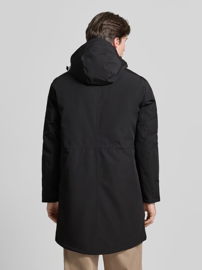 Männermodel trägt Jacke mit Kapuze von MCNEAL, Herren, Regular-Fit, schwarze Oberfläche, Ganzkörperansicht Rückansicht. Rückenlänge 99 cm, Schulterbreite 48 cm, Brustweite 62 cm, Ärmellänge 67 cm, verdeckter Reißverschluss, Pattentaschen, Reißverschlusstasche am Ärmel.