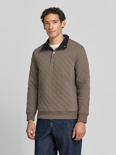 Männermodel trägt Regular Fit Troyer aus Baumwoll-Mix von GANT, unifarben, strukturierte Sweat-Optik, Stehkragen, Ganzkörperansicht von vorne.