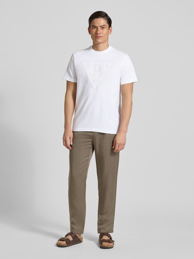 Mannenmodel draagt T-Shirt met Logo en Rondhalsuitsnijding van Guess, witte katoen, regular fit, logoprint, ruglengte maat M 70 cm, volledige lichaamsaanzicht van voren.