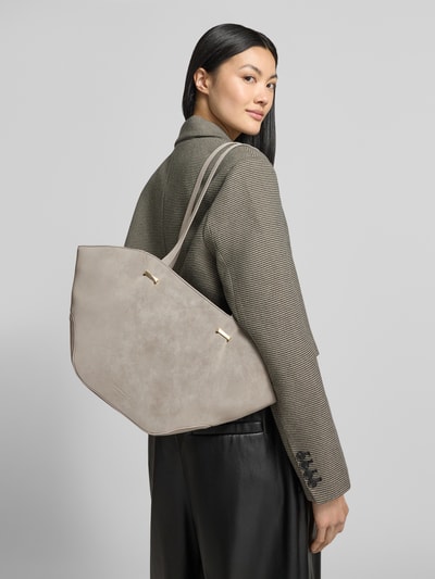 Frauenmodel trägt Shopper in Leder-Optik Modell 'Rena' von Seidenfelt, beige, Logo-Detail, schmale Schulterriemen, Ganzkörperansicht Rückansicht.