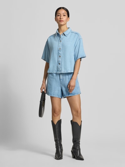 Vrouwenmodel draagt Regular Fit overhemdblouse uit puur lyocell model 'Saphina' van MSCH Copenhagen, denimlook, halflange mouwen, overhemdkraag, doorlopende knoopsluiting, ruglengte maat S/M 53 cm, mouwlengte maat S/M 22 cm, lichtblauw, gestructureerde stof, effen, voorkant volledig te zien