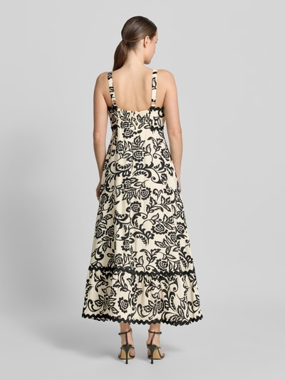Modelka nosi Midikleid aus Viskose-Mix mit Wellensaum od Apricot, kremowy w czarny wzór, taliowany fason, prostokątny dekolt, szerokie ramiączka, marszczony detal i zapięcie na haftkę i zamek błyskawiczny z tyłu, długość tyłu w rozmiarze S: 118 cm, szerokość w rozmiarze S: 40 cm, widok całej sylwetki od tyłu.