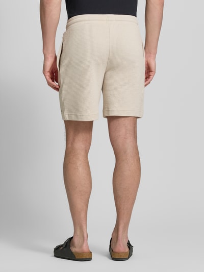 Männermodel trägt Regular Fit Sweatshorts aus Baumwoll-Mix Modell 'AUSTIN' von HUGO, Optik: Unifarben, Waffelstruktur, Ganzkörperansicht Rückansicht.