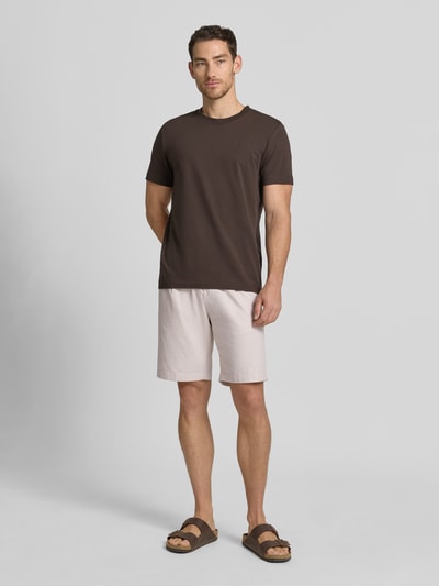 Männermodel trägt Bermudas mit französischen Eingrifftaschen Modell 'COLI' von Fynch-Hatton, Baumwoll-Mix mit Leinen-Anteil, Loose-Fit, elastischer Bund mit Kordelzug, sandfarben, Querstruktur, Ganzkörperansicht von vorne.