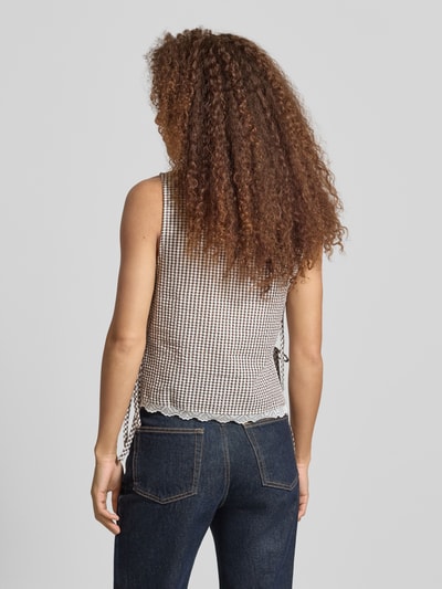 Modelka nosi Blusentop mit seitlicher Schnürung Modell 'ELIZA' von Noisy May, mieszanka bawełny, krój regular fit, okrągły dekolt, wiązanie z boku, długość tyłu przy rozmiarze S: 50 cm, przód i boki drobna krata, tekstura lekko prążkowana, Ganzkörperansicht Rückansicht.