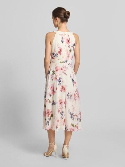 Frauenmodel trägt Midikleid mit floralem Allover-Print von Christian Berg Cocktail, Tailliert, Rundhalsausschnitt, Gelegte Falten, Ärmelloses-Design, Nahtreißverschluss, cremefarbener Grundton mit rosa und lila Blumenmotiven, Rückenlänge 115 cm, Brustweite 40 cm, Ganzkörperansicht Rückansicht.