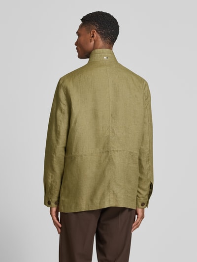 Mężczyznamodel nosi Leinenjacke mit Stehkragen und Pattentaschen von bugatti, zielony len, krój regular fit, guzik, patkowe kieszenie, długość pleców w rozmiarze 50: 74 cm, szerokość ramion w rozmiarze 50: 46 cm, szerokość klatki piersiowej w rozmiarze 50: 55 cm, długość rękawa w rozmiarze 50: 64 cm, widok całej sylwetki z tyłu