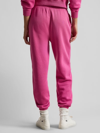 Frauenmodel trägt Comfort Fit Sweatpants aus reiner Baumwolle von Polo Ralph Lauren in Pink mit elastischem Bund, Sweat-Material, Ganzkörperansicht Rückansicht.