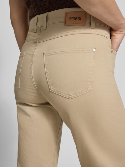 Frauenmodel trägt Bootcut Hose mit Eingrifftaschen Modell 'Lara' von Angels, beigefarbener Baumwoll-Mix, Nahaufnahme Rückansicht.