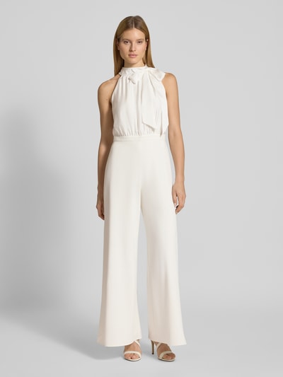 Vrouwenmodel draagt Jumpsuit met Schleifen-Applikation van SWING in crèmewit, getailleerd model, halter, wijde benen, cut-out op de rug, ganzekörperaanzicht van voren.
