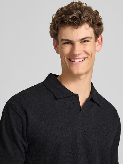 Männermodel trägt Relaxed Fit Poloshirt aus Baumwoll-Mix von Marc O'Polo Denim in Optik: Unifarben, Crinkle-Optik, Nahaufnahme Oberkörper.