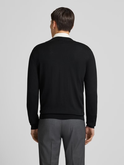 Männermodel trägt Cardigan mit Label-Detail Modell 'Balonso' von BOSS aus reiner Schurwolle, unifarbenes Design, gerader Schnitt, Ganzkörperansicht Rückansicht.