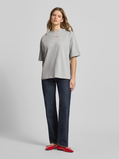 Kobiece model nosi damski t-shirt z bawełny o kroju oversized model 'Lotte' z okrągłym dekoltem i nadrukiem z logo LeGer by Lena Gercke, długość tyłu w rozmiarze 36: 66 cm, widok całej sylwetki z przodu.