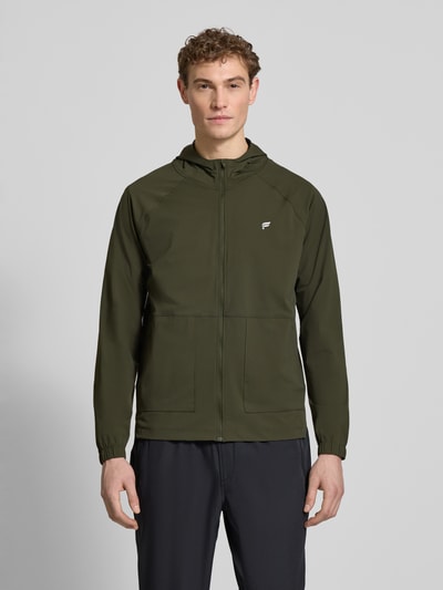 Männermodel trägt Regular Fit Jacke mit Kapuze Modell 'The One' von Fabletics im Elastischer-Material-Mix, Logo-Print, Ganzkörperansicht von vorne.