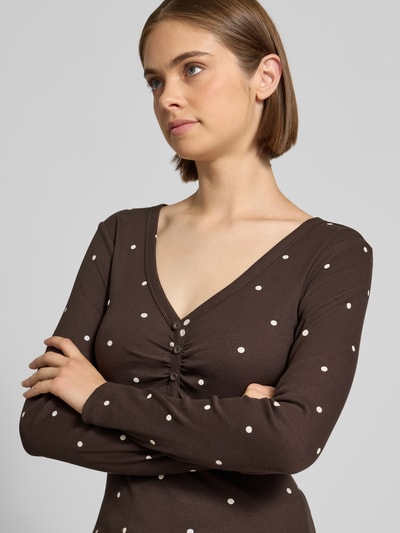Frauenmodel trägt Regular Fit Langarmshirt aus Baumwoll-Mix Modell 'FENJA' von ONLY, braun mit weißen Punkten, Nahaufnahme Oberkörper, Damen Langarmshirt von ONLY