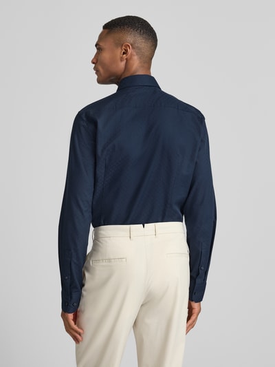 Männermodel trägt Slim Fit Businesshemd mit Haifischkragen von JOOP! Collection in Dunkelblau mit Allover-Print aus reiner Baumwolle, Ganzkörperansicht Rückansicht.