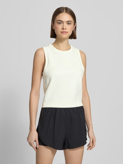 Frauenmodel trägt Tanktop mit geripptem Rundhalsausschnitt von adidas Sportswear im Material-Mix mit Modal-Anteil, lockerem Schnitt, Label-Detail in Weiß und Schwarz, Rückenlänge bei Größe S: 50 cm, Ganzkörperansicht von vorne.
