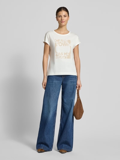 Frauenmodel trägt Regular Fit T-Shirt mit Statement-Print von monari, Baumwoll-Modal-Mix, Rundhalsausschnitt, Kurzärmelig, Rückenlänge 56 cm, Ganzkörperansicht von vorne.