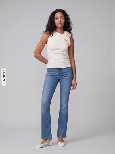 Frauenmodel trägt Slim Fit Bootcut-Jeans aus Baumwoll-Mix mit Lyocell-Anteil Modell '725 HIGH RISE BOOTCUT' von Levi's® 300 in Hellblau, kombiniert mit cremefarbenem Oberteil, neutrale Studiofarben, Ganzkörperansicht von vorne, Kontext: Damen Bootcut-Jeans von Levi's® 300, KI-modifiziertes Bild.