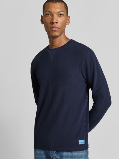 Männermodel trägt Regular Fit Sweatshirt aus reiner Baumwolle von Scotch & Soda, dunkelblau, Strukturmuster, Nahaufnahme Oberkörper.