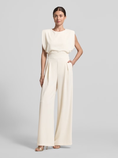 Kobiece model prezentuje Regular Fit Jumpsuit mit Rundhalsausschnitt od Rinascimento, kremowy kolor, gładka tekstura, krój regular fit, bez rękawów, kellerfałdy, top z okrągłym dekoltem, taliowana forma, długość całkowita 150 cm w rozmiarze S, szerokość w rozmiarze S: 45 cm, długość tyłu 50 cm, długość nogawki wewnętrznej 86 cm, widok całej sylwetki z przodu.