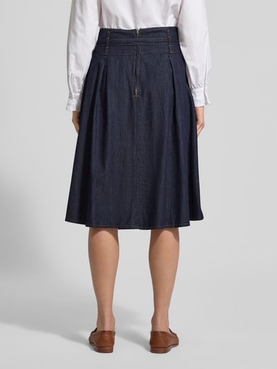 Frauenmodel trägt Midirock in Denim-Optik von More & More aus reiner Baumwolle, lockerer Schnitt, Stoffgürtel, Reißverschluss, Ganzkörperansicht Rückansicht.